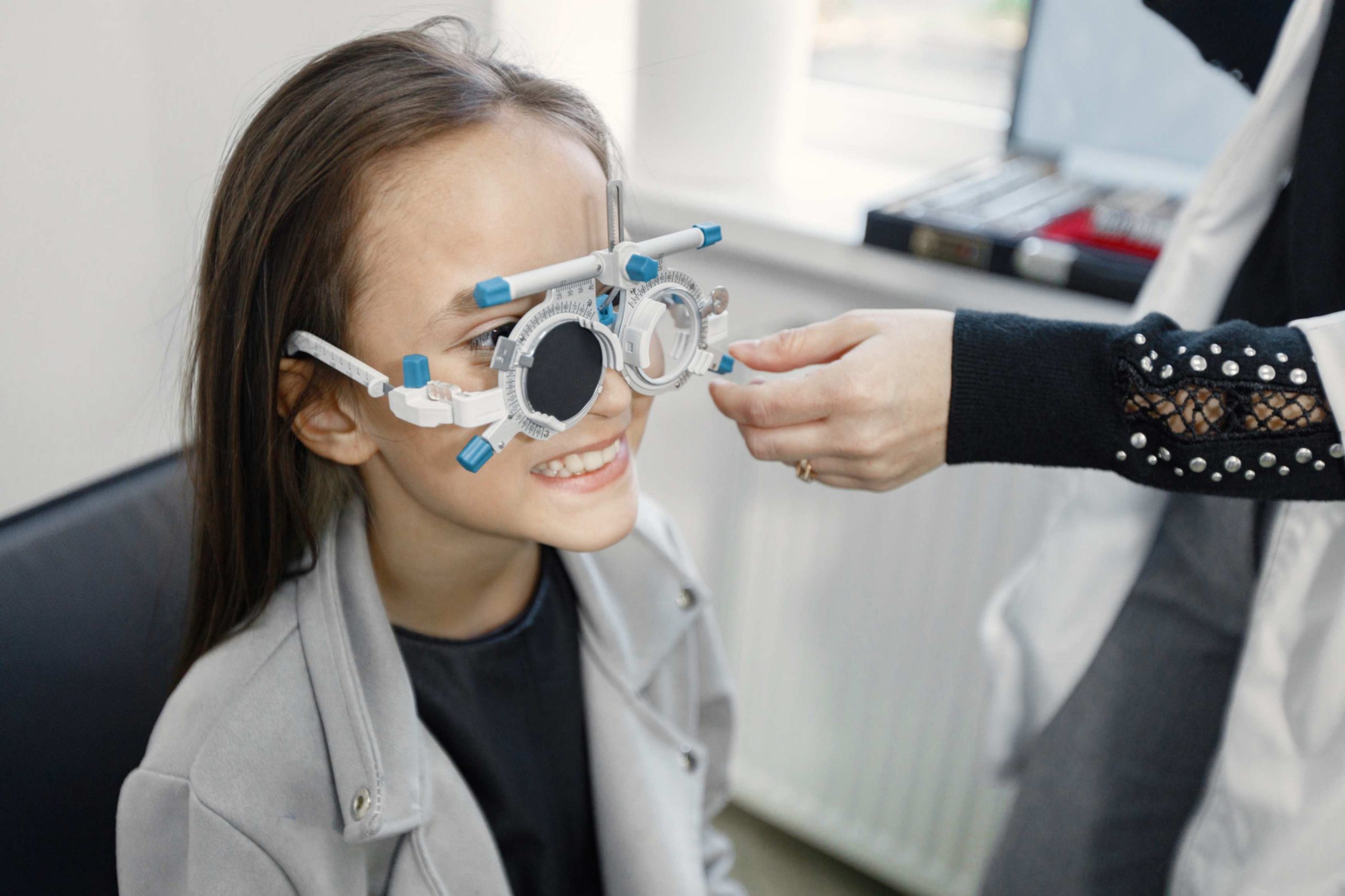 jpeg optimizer little girl checking up her sight ophthalmology center female optometrist doing sight testing brunette girl wearing grey jacket black shirt scaled